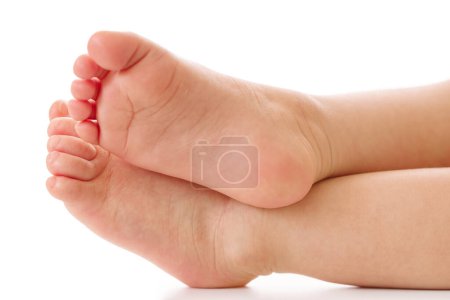 Téléchargez les photos : Gros plan des pieds d'un petit enfant avec une peau lisse et douce sur fond blanc. - en image libre de droit