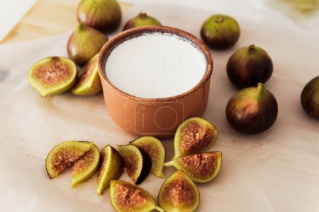 Téléchargez les photos : Gros plan de délicieux yaourt grec naturel dans un bol d'argile à la figue - en image libre de droit