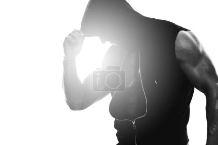 Foto de Retrato monocromático de un extraño musculoso con capucha sin mangas sobre fondo blanco - Imagen libre de derechos