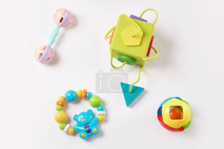 Foto de Primer plano de una colección de juguetes de plástico de colores y rompecabezas para niños pequeños, bueno para el desarrollo de la lógica y la habilidad motora fina sobre fondo blanco. - Imagen libre de derechos