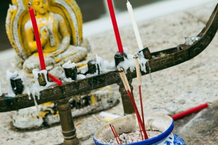 Foto de Primer plano de un altar budista con velas y oración estatua de Buda en el fondo. - Imagen libre de derechos