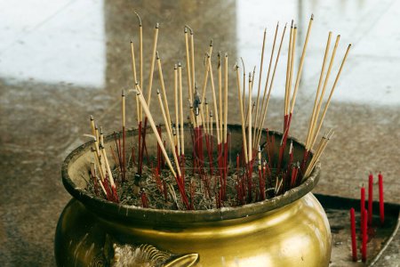 Téléchargez les photos : Gros plan d'un vieil encensoir traditionnel rempli de bâtons fumants dans un temple bouddhiste. - en image libre de droit