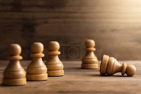 Foto de Primer plano de ajedrecistas de madera de pie con un peón de ajedrez mintiendo. Concepto de problema social y acoso escolar. - Imagen libre de derechos