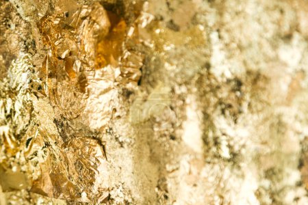 Photo for Abstract closeup shot of a uneven surface covered with exfoliated crumpled gold foil. - Royalty Free Image