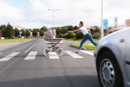 Photo for Inconsiderate mother trying to catch her baby pram rolled out on the road with a moving car - Royalty Free Image
