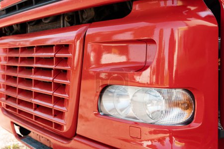 Photo for Closeup of front part of the red truck with radiator grille and headlight - Royalty Free Image