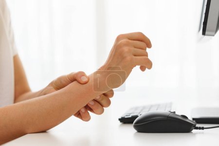Foto de Primer plano de las manos femeninas con dolor en la muñeca debido al síndrome del túnel carpiano - Imagen libre de derechos