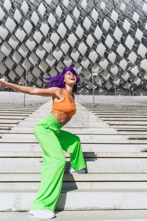 Foto de Bailarina activa con ropa deportiva colorida actuando en la calle durante el día de verano - Imagen libre de derechos