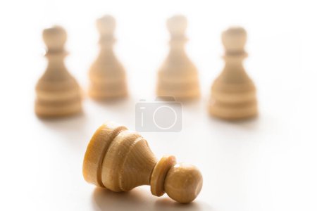 Foto de Primer plano de ajedrecistas de madera de pie con un peón de ajedrez mintiendo. Concepto de problema social y acoso escolar. - Imagen libre de derechos