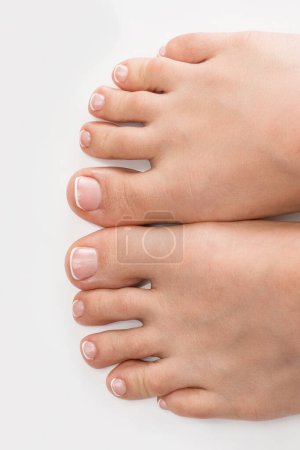 Téléchargez les photos : Gros plan de pieds féminins à la peau douce et pédicure française sur fond blanc - en image libre de droit