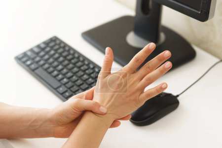 Téléchargez les photos : Gros plan des mains féminines avec une douleur au poignet à cause du syndrome du canal carpien - en image libre de droit