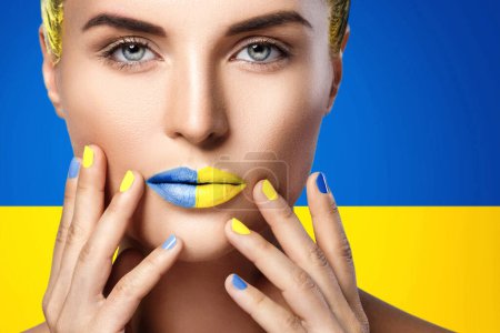 Téléchargez les photos : Femme confiante avec rouge à lèvres jaune bleu et drapeau ukrainien sur fond - en image libre de droit