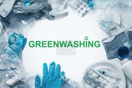 Montón de residuos plásticos y letras Greenwashing. Concepto de estafa verde, relaciones públicas verdes y marketing de fraude.