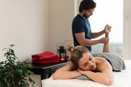 Téléchargez les photos : Jeune et belle femme pendant le massage des pieds dans une clinique de massage professionnelle - en image libre de droit