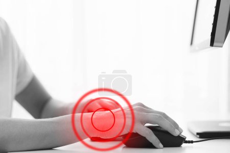 Téléchargez les photos : Jeune femme travaillant au bureau avec un syndrome du canal carpien ou une inflammation des articulations du poignet - en image libre de droit