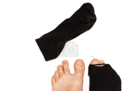 Photo for Closeup shot of male feet with a toe sticking out from a single hoaly black sock on white background. Concept of poverty and financial crisis. - Royalty Free Image