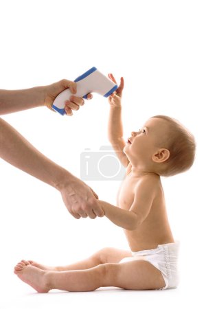 Foto de Madre está usando termómetro electrónico para medir la temperatura corporal de su hijo pequeño sobre fondo blanco. - Imagen libre de derechos