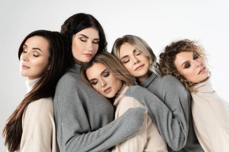Téléchargez les photos : Groupe de différentes femmes portant des pulls à col roulé sur fond gris. Diversité, amitié et autres concepts. - en image libre de droit