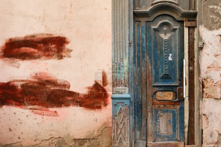 Téléchargez les photos : Porte en bois minable dans un vieux bâtiment avec des murs fissurés - en image libre de droit