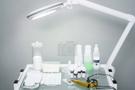 Photo for Permanent makeup artist workplace with a machine, different equipment and bottles - Royalty Free Image