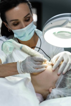 Foto de Artista de maquillaje permanente profesional y su cliente durante el tratamiento de mejora de la línea de pestañas - Imagen libre de derechos
