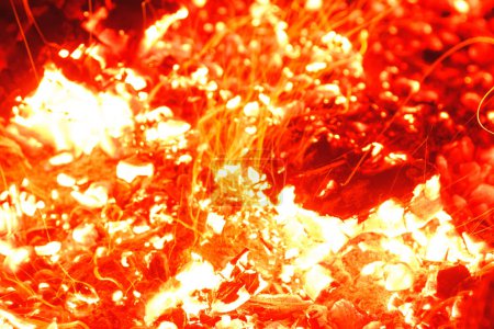 Photo for Closeup shot of campfire brightly burning at night and throwing sparkles around. - Royalty Free Image