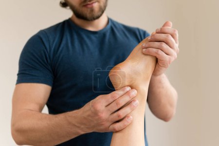 Téléchargez les photos : Masseur homme pendant le traitement de médecine intégrative massage des pieds féminin - en image libre de droit