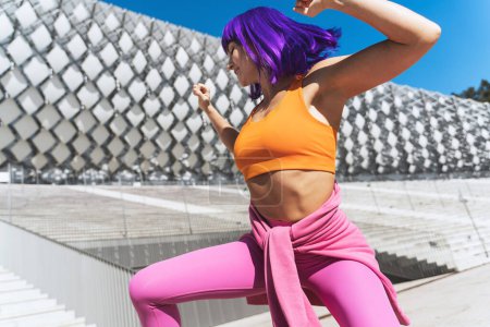 Photo for Carefree active woman dancer wearing colorful sportswear having fun on the street during sunny day - Royalty Free Image