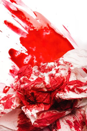 Téléchargez les photos : Serviette en papier sale et peinture rouge ressemblant à du sang sur fond blanc - en image libre de droit