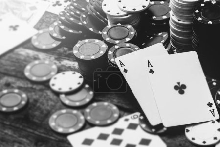 Téléchargez les photos : Image monochrome de deux as et beaucoup de jetons de casino sur une table en bois - en image libre de droit