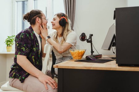 Foto de Joven pareja sensual relajándose y mostrando amor mientras juega videojuegos en un ordenador personal - Imagen libre de derechos