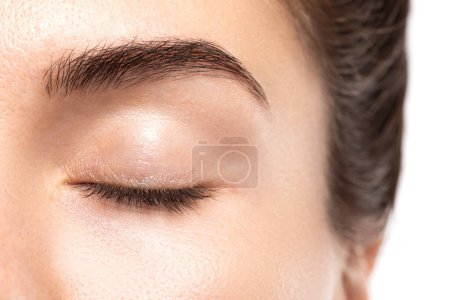 Primer plano de ojo femenino joven sin maquillaje con un espacio de copia