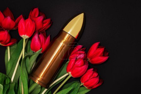 Téléchargez les photos : Pacifisme, mouvement non-violent ou Jour de la Victoire. Grosse balle et bouquet de tulipes rouges. - en image libre de droit