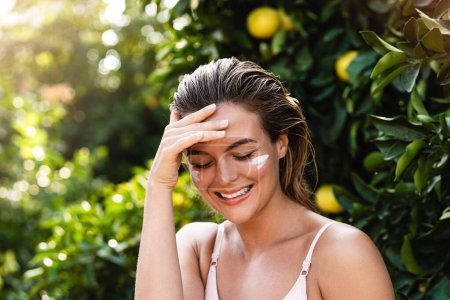 Photo for Outdoor portrait of beautiful woman with moisturizing cream under her eyes - Royalty Free Image