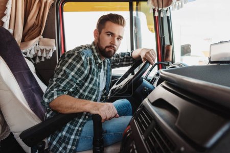 Photo for Young and handsome professional truck driver sitting inside his vehicle - Royalty Free Image
