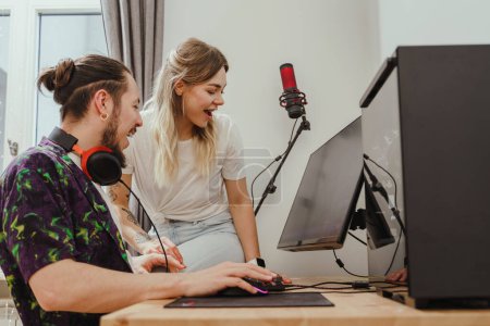 Photo for Young cheerful couple playing video game together on modern personal computer - Royalty Free Image