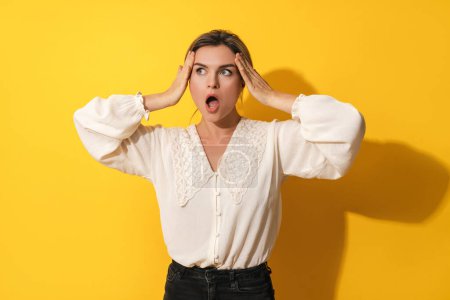 Photo for Portrait of young surprised woman against yellow background - Royalty Free Image
