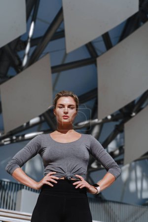 Téléchargez les photos : Athlète femme confiante portant des vêtements de sport féminins posant sur fond futuriste moderne. - en image libre de droit