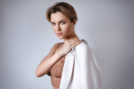 Foto de Retrato de mujer atractiva joven con lencería marrón y blazer blanco. - Imagen libre de derechos