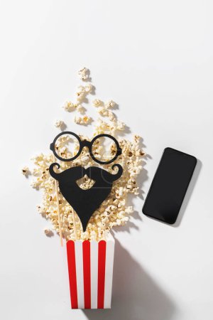 Photo for Delicious popcorn, party props and smartphone with blank screen for your design. - Royalty Free Image