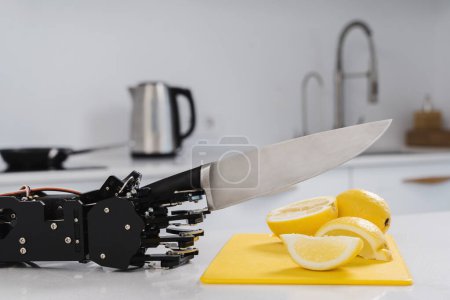 Téléchargez les photos : Le vrai robot coupe les citrons à la main avec un couteau tranchant. Concept d'automatisation robotique des processus. - en image libre de droit
