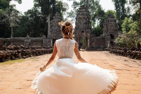 Foto de Hermosa joven vestida con túnica blanca en antiguas ruinas Khmer, Angkor Wat - Imagen libre de derechos