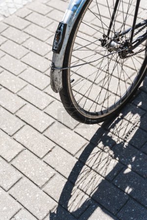 Photo for Iron road bicycle on a city street, casting a shadow in the sunlight with no people around. - Royalty Free Image