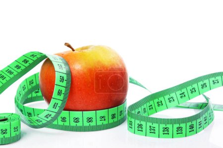 Photo for Fresh apple and green tape measure on white background. - Royalty Free Image