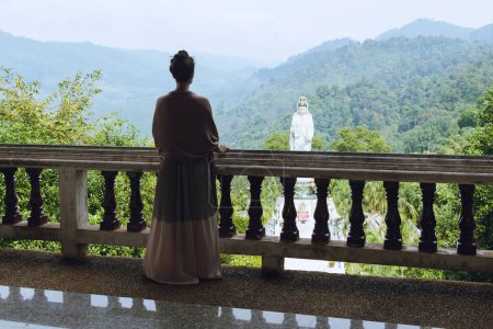 Téléchargez les photos : Jeune femme dans un ancien palais asiatique, ornée d'une robe longue et fluide et d'une écharpe drapant ses épaules - en image libre de droit