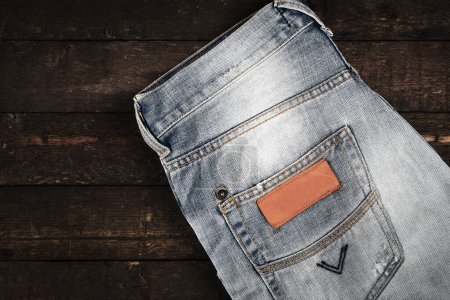 Foto de Primer plano de jeans sobre fondo de madera. - Imagen libre de derechos
