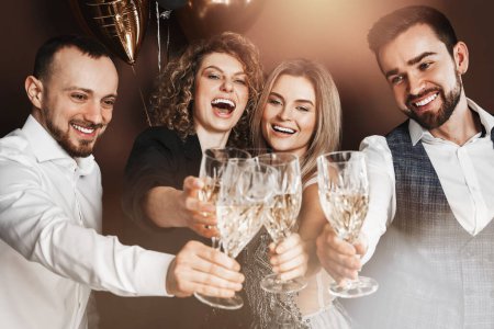 Photo for Group of elegantly dressed people celebrating a holiday or event, drinking sparkling wine. - Royalty Free Image
