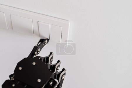 Foto de La mano del robot real presionando el botón en un interruptor de luz. Concepto de automatización robótica de procesos. - Imagen libre de derechos