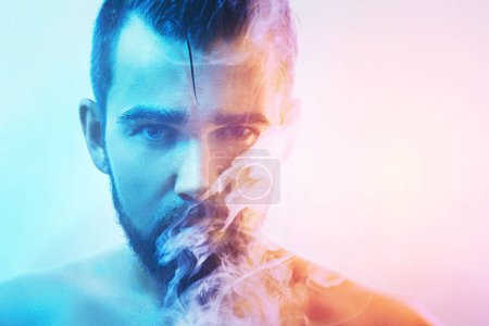 Photo for Handsome young man with wet skin in colorful light smoking cigarette or marijuana. - Royalty Free Image