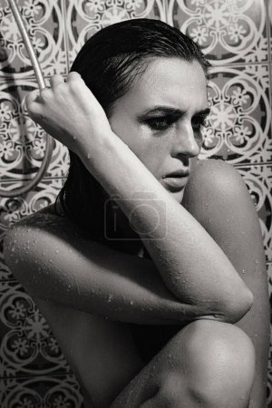 Foto de Retrato monocromático de mujer triste y húmeda con maquillaje manchado en su cara bajo la ducha - Imagen libre de derechos
